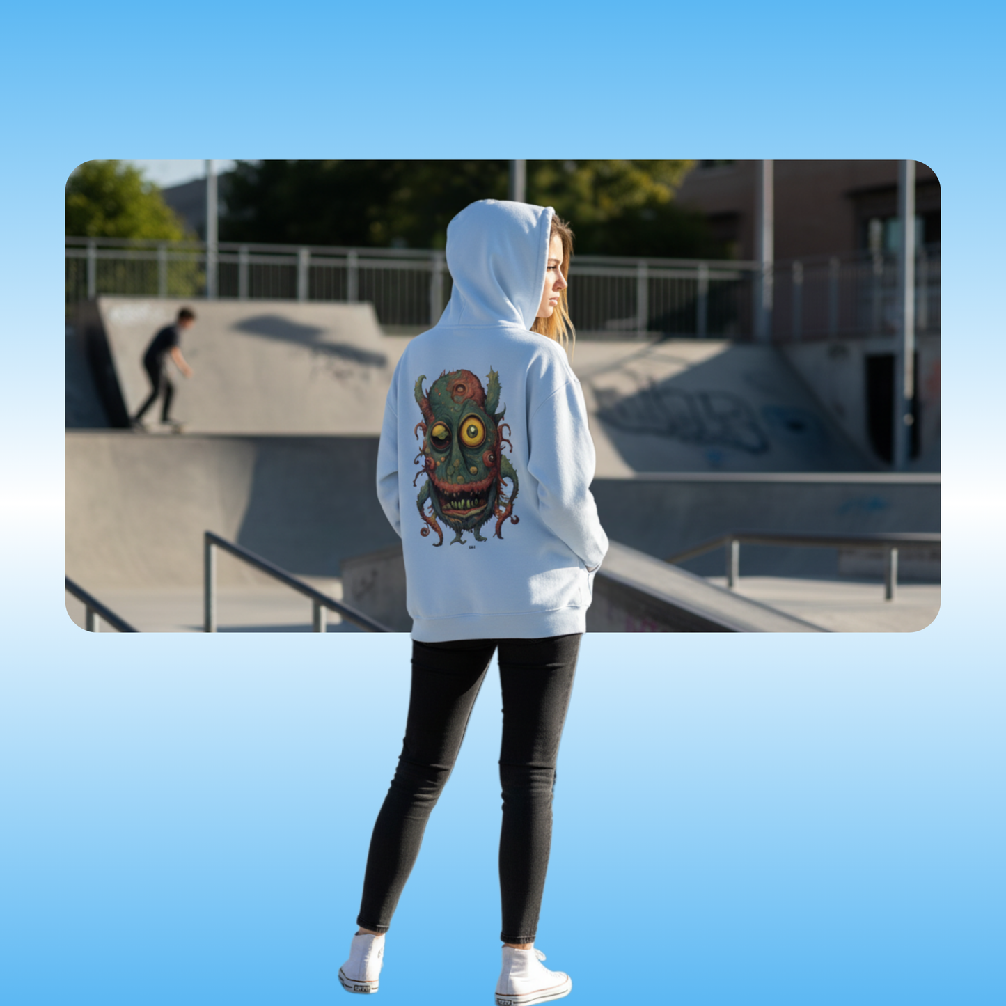 Bill | Hooded Jacket | Paddle Frogs™ model showcasing the backside of the light blue hoodie at a skatepark | Person wearing a light blue hoodie with a colorful design at a skate park