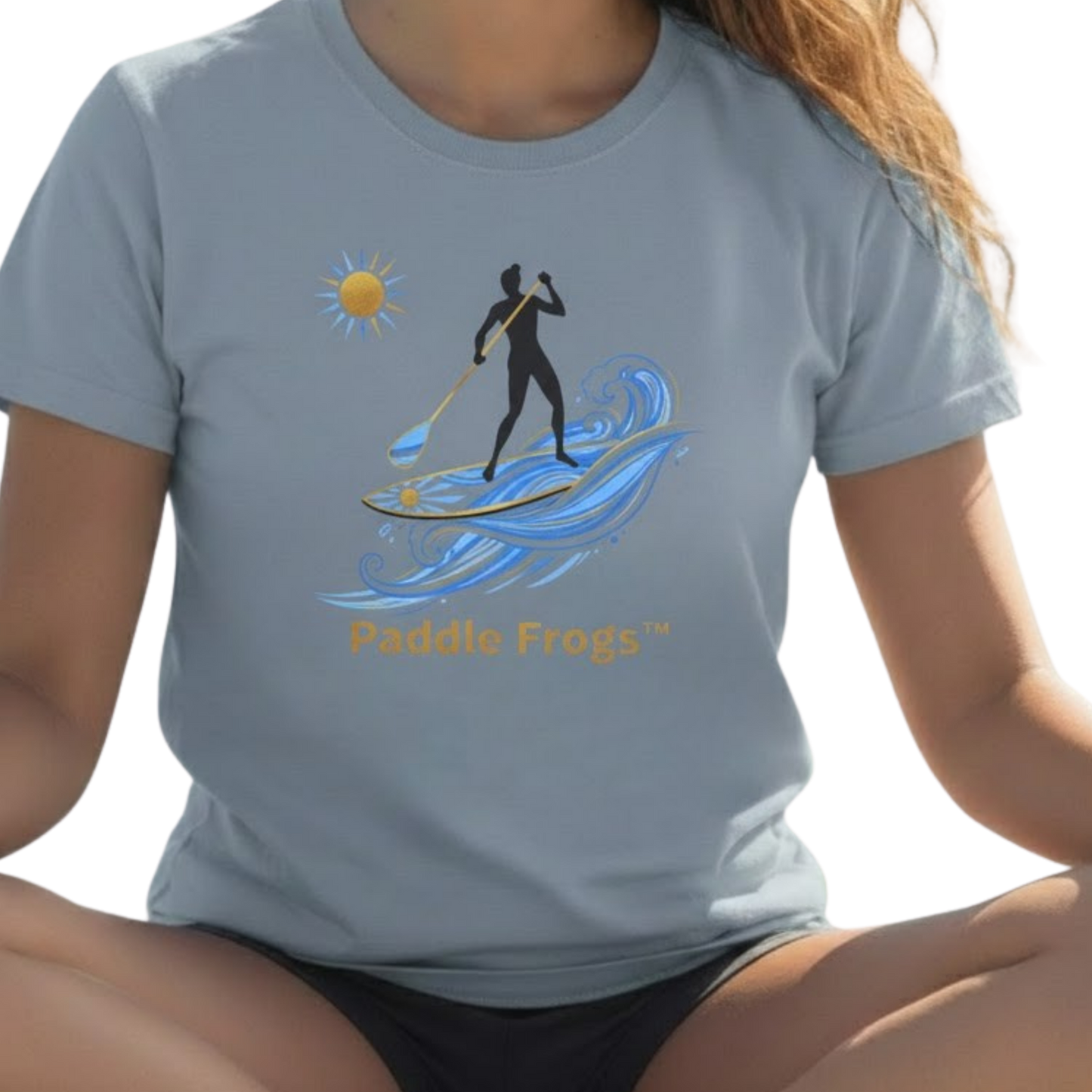 Person wearing a light blue t-shirt with a paddleboarding design and 'Paddle Frogs' text on a transparent background