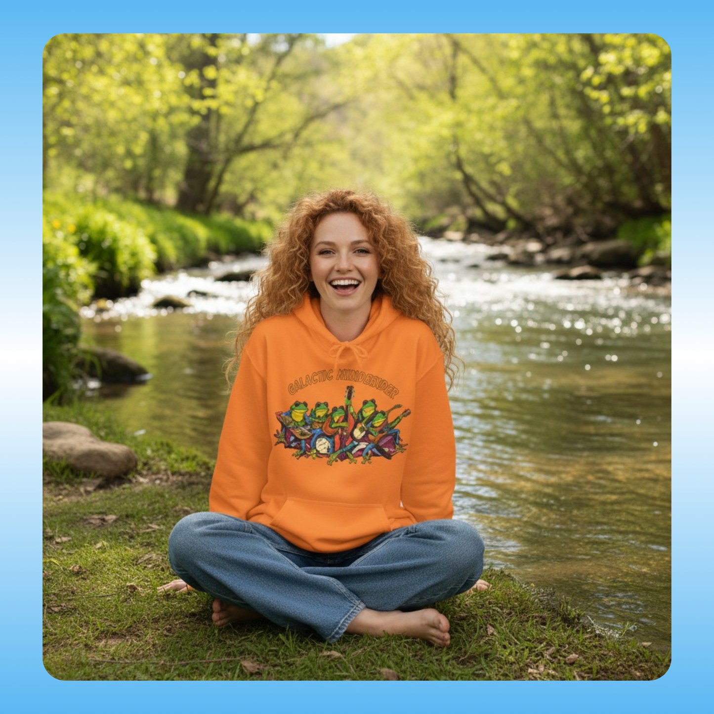 Galactic Mindbender fleece hoodie | Person wearing an orange hoodie with a colorful design sitting by a river