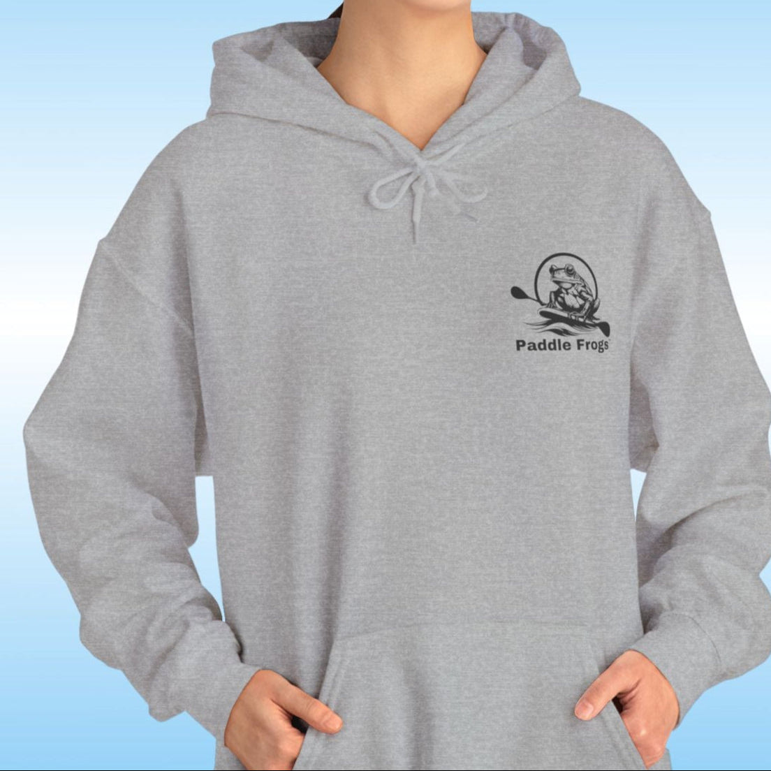 Paddle Frogs original Hoodie in multiple colors Person wearing a gray hoodie with a logo on a blue gradient background