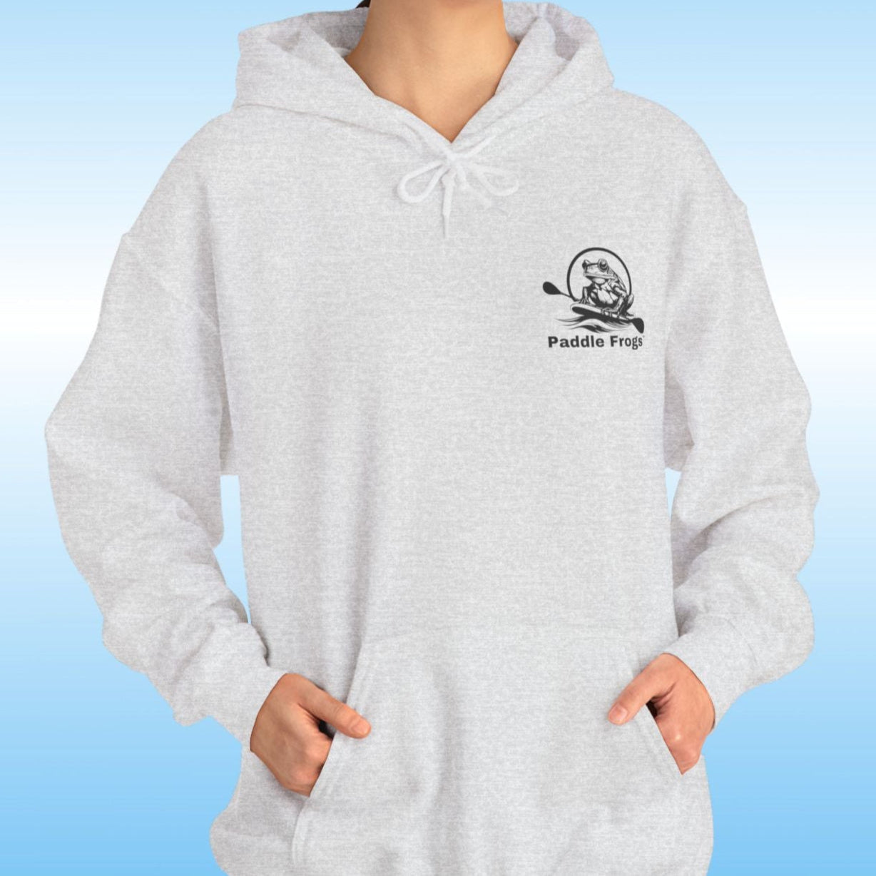 Paddle Frogs original Hoodie in multiple colors Person wearing a light heather grey hoodie with a logo on a blue background