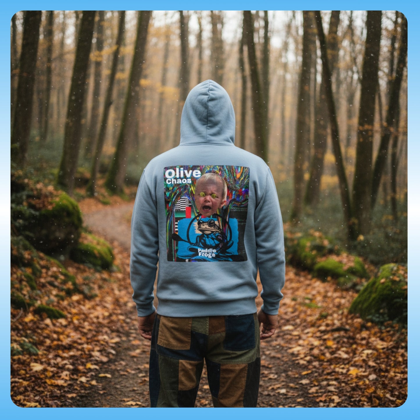 olive Chaos Stone Blue Paddle Frogs Outdoor Gear Hoodie pull over coat Person wearing a hoodie with a colorful graphic on the back, standing in a forest.