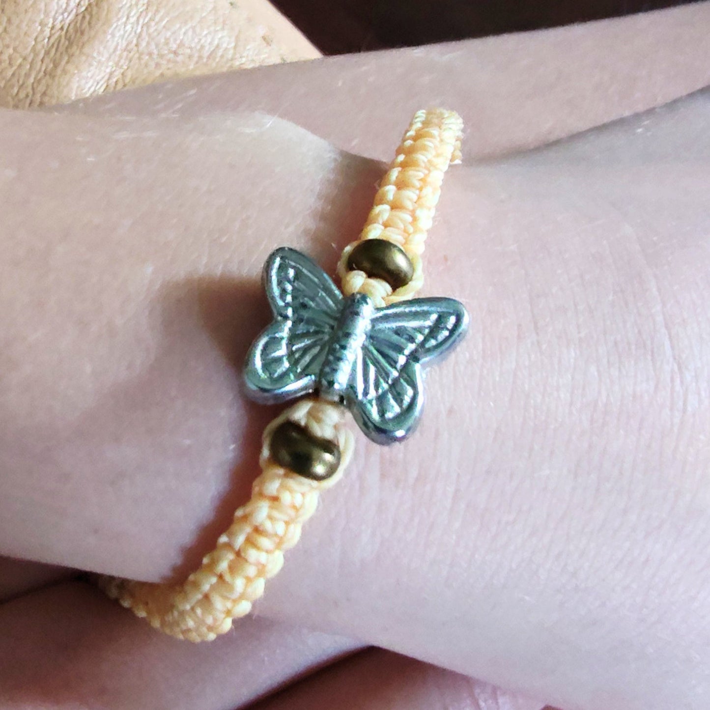Beaded BFF friendship bracelet with a butterfly charm on a wrist