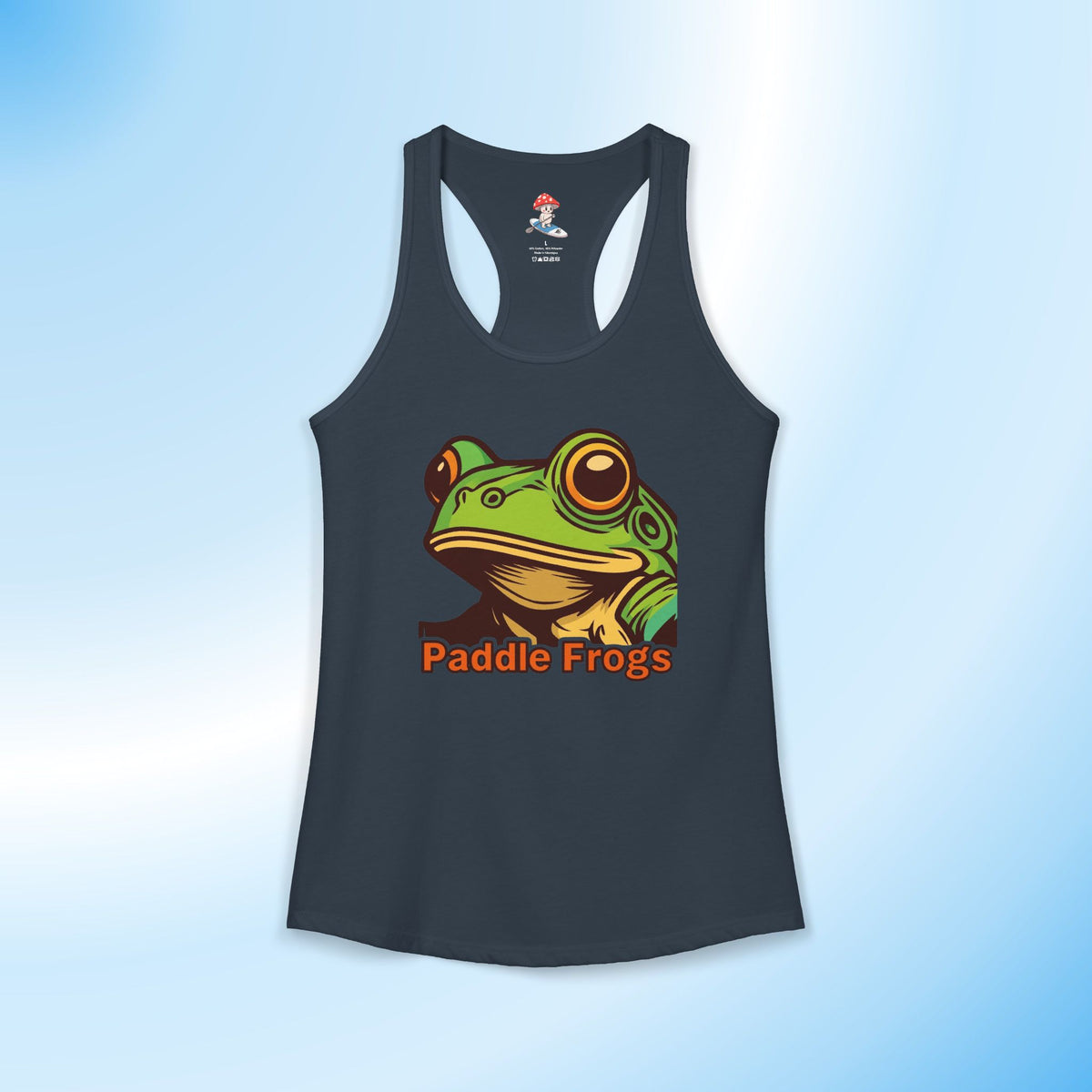 A dark solid indigo racerback tank top featuring a colorful graphic of a green frog with large eyes and the text 'Paddle Frogs' in orange below it, displayed against a light blue gradient background.