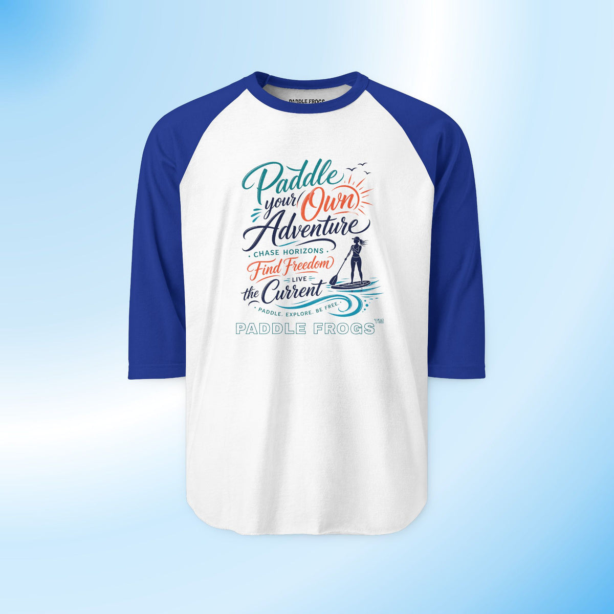 A 3/4 sleeve raglan t-shirt with a white body and royal blue sleeves, featuring a colorful graphic print on the front with the text 'Paddle your Own Adventure' and 'Paddle Frogs'.