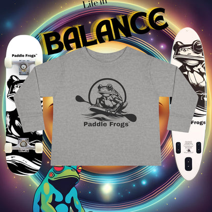Gray t-shirt with 'Paddle Frogs' logo on a colorful background with a paddle board and a skateboard and frogs.