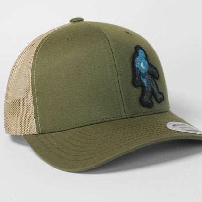 Green and beige cap with Bigfoot on a light gray background