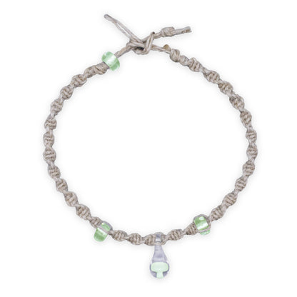 Bracelet with gray cord and green beads on a white background