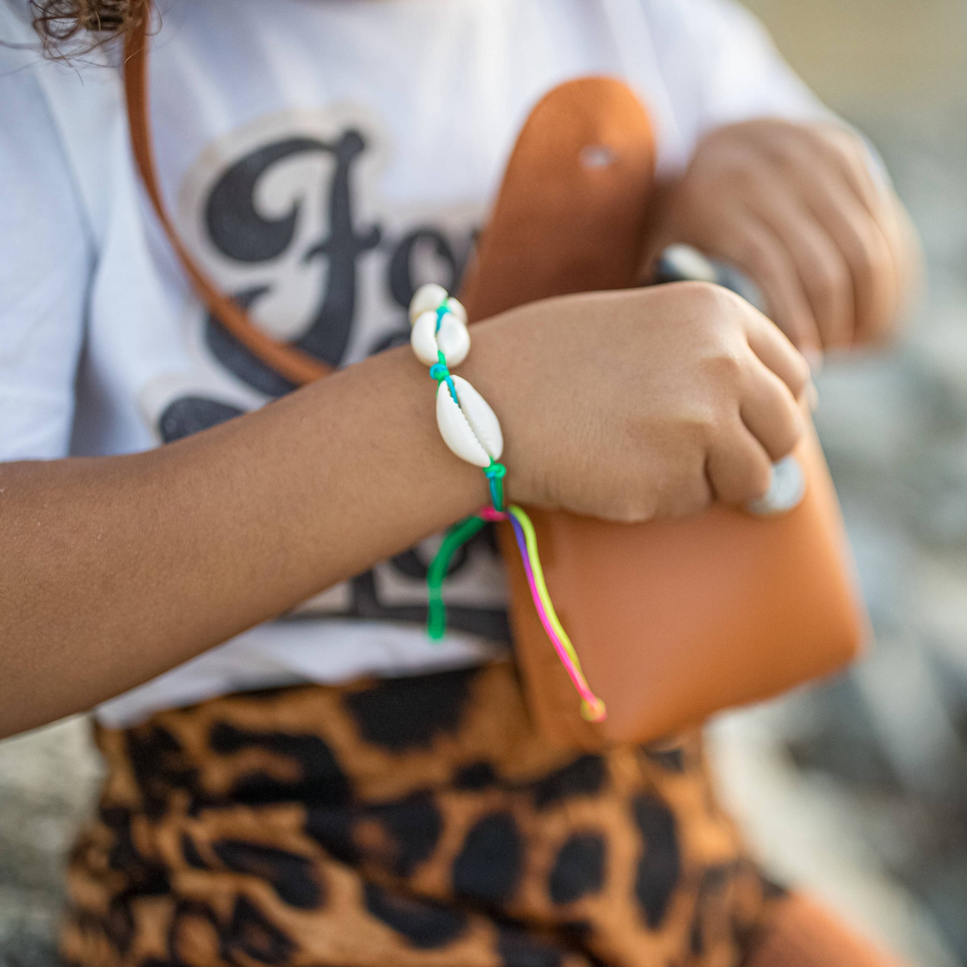 Person wearing a colorful bracelet on a blurred background