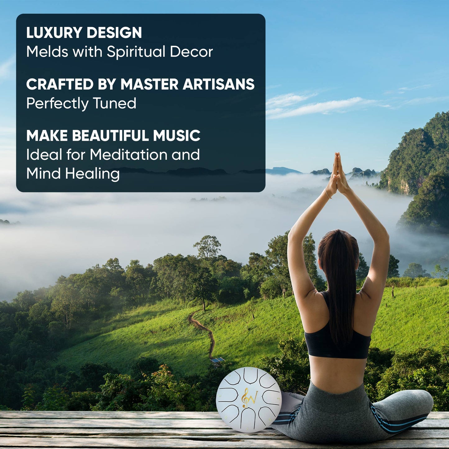 Person meditating with a tingsha drum on a wooden platform overlooking a scenic landscape.