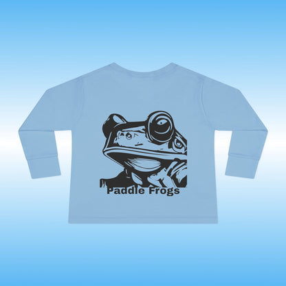 Light blue long-sleeve shirt with a black frog graphic and 'Paddle Frogs' text on a light blue background