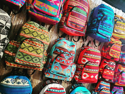 Colorful patterned backpack bags on a wall