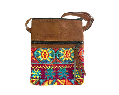 Brown leather crossbody bag with colorful embroidered pattern on a white background