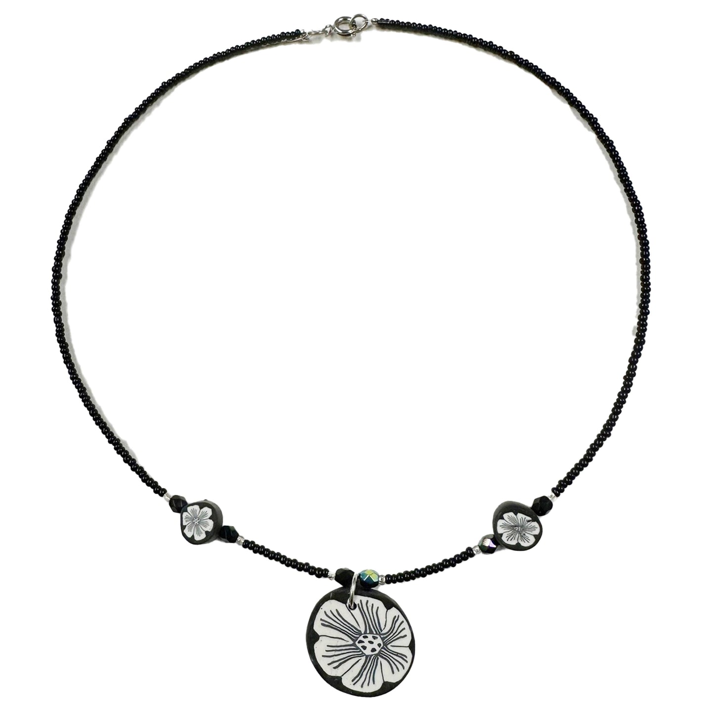 Necklace with a black cord and floral pendant on a white background