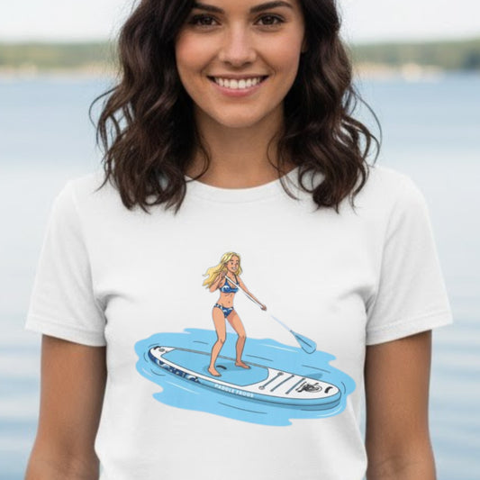 Woman wearing a white t-shirt with a graphic of a woman on a paddleboard. Aqua Babe Tee -Divine Escape paddleboard shirt White color modeled by the crew at Harrison Bay State Park in Tennessee