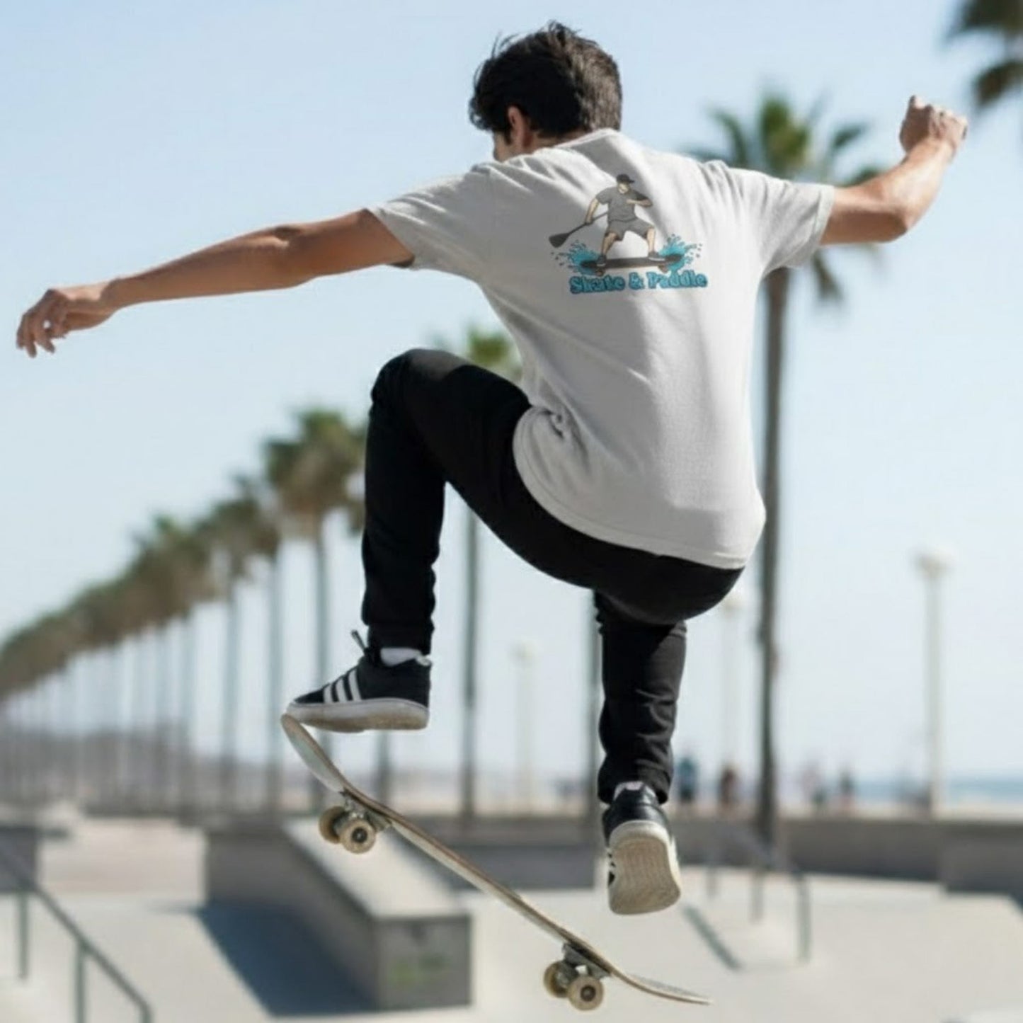 Asphalt Meets Water | Skate & Paddle Tee by Paddle Frogs™ Backside Ice Grey color man skateboarding at the beach ollie