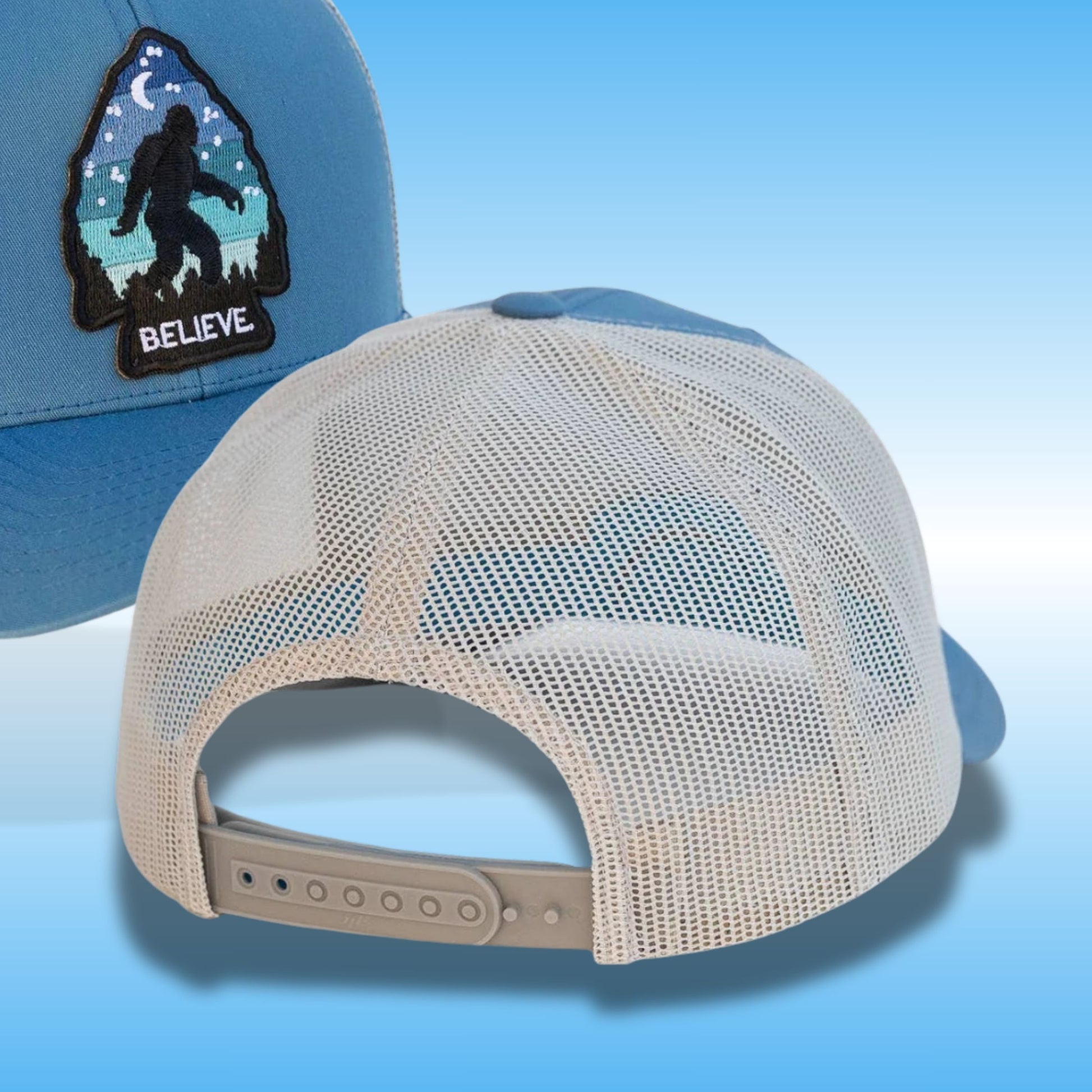A light blue trucker-style cap shown from the back, with a silver mesh back and an adjustable beige strap. A matching light blue front panel is partially visible on the left, featuring a black arctic-style patch with a Bigfoot silhouette and the word 'BELIEVE'.