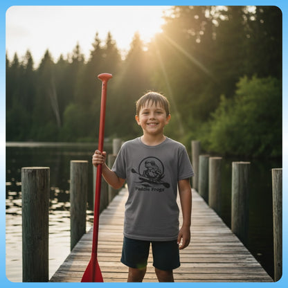 Charcoal Gray action shot - Kids Tee (Big Fit) 7 Colors | Paddle Frogs Kids | Child holding a red paddle on a wooden dock with trees and sunset in the background