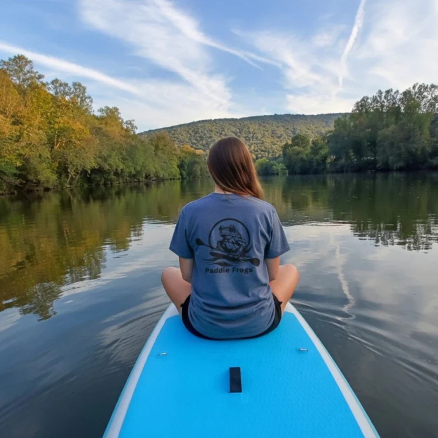 Divine Escape paddle board in the Emory River: Sitting crisscross applesauce in the Emory river - wearing River's Companion Tee: A Paddle Frog's Ode to the Current