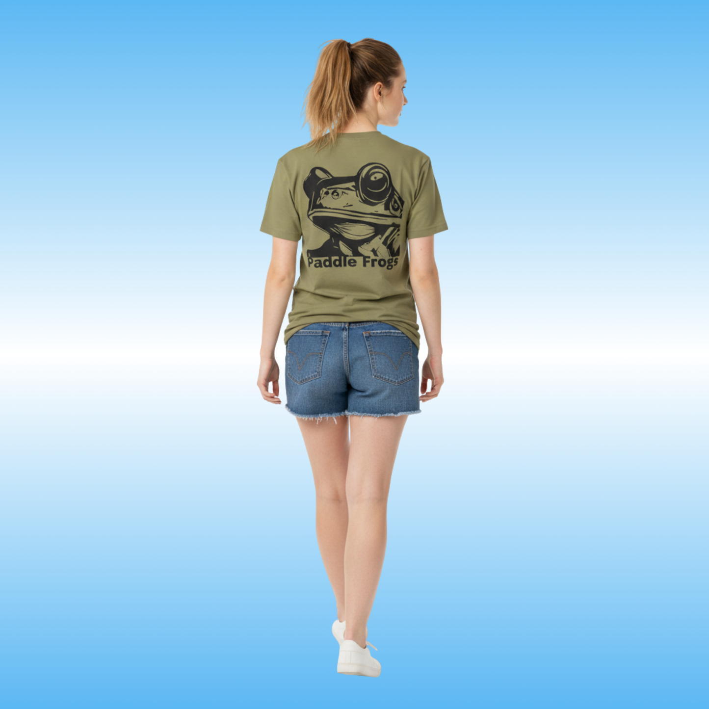 Earthy Tee | Paddle Frogs™ Person wearing a green t-shirt with a frog graphic and 'Paddle Frog' text on a blue background