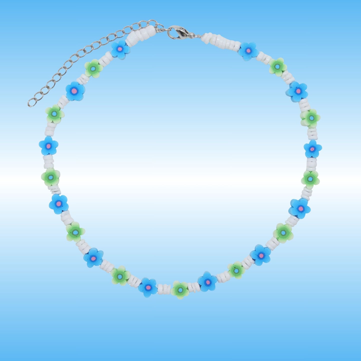 A beaded necklace with alternating blue and green flower beads, white spacer beads, and a silver-tone chain clasp, shown on a light blue gradient background.