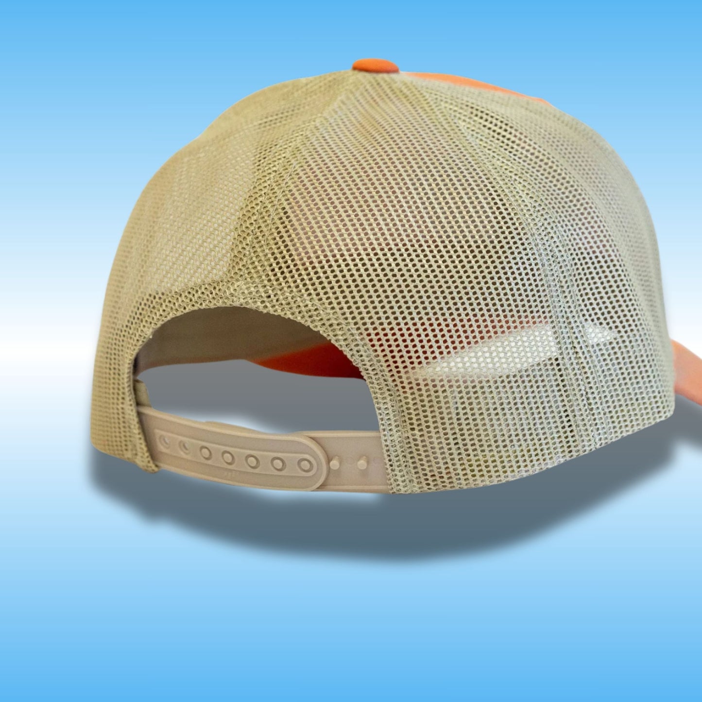 A beige mesh-back baseball cap shown from the back, featuring a light beige adjustable strap and small orange accents on the top button and underbrim, set against a blue gradient background.