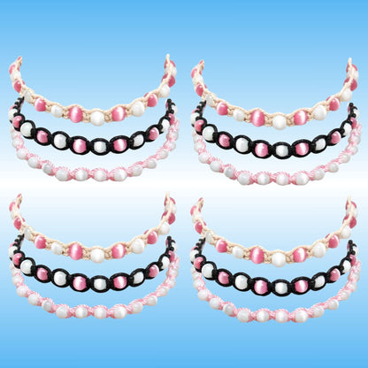 Four matching beaded headbands arranged in a 2x2 grid on a light blue gradient background. Each headband features three rows of beads: a top row of white pearl-like beads, a middle row of alternating pink and white beads, and a bottom row of alternating black and pink beads.
