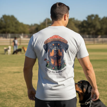 Man wearing a t-shirt with a Rottweiler graphic and text, standing in a park with dogs.