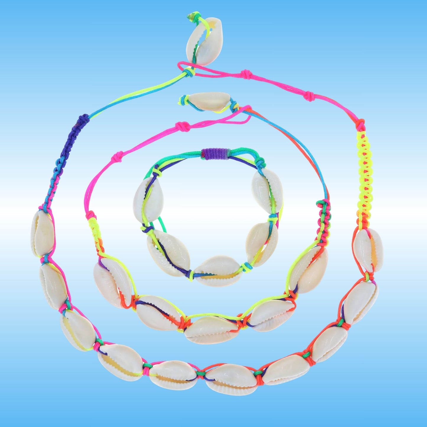 A set of three jewelry pieces made of natural cowrie shells threaded on bright neon multicolored cords, displayed on a light blue gradient background.