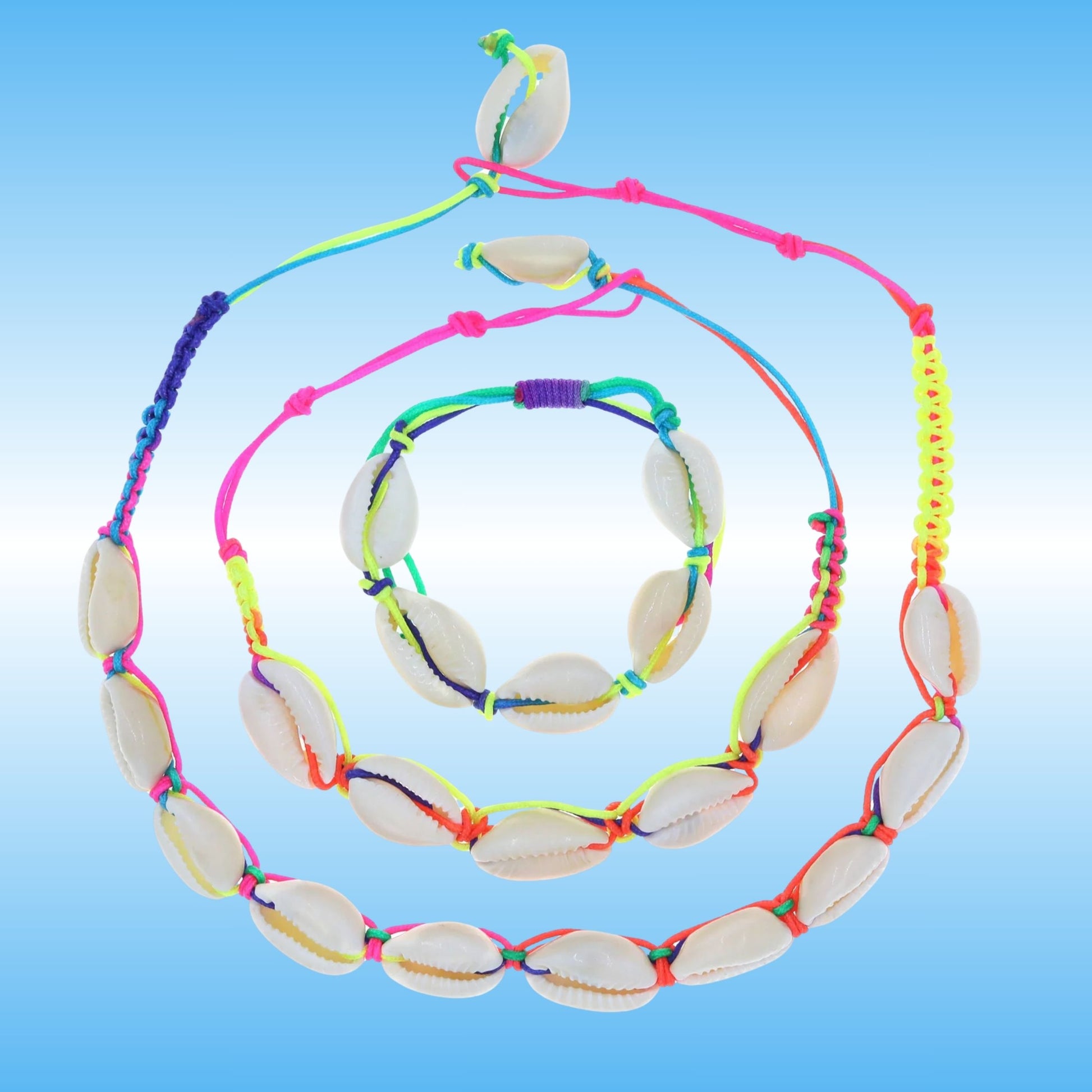 A set of three jewelry pieces made of natural cowrie shells threaded on bright neon multicolored cords, displayed on a light blue gradient background.