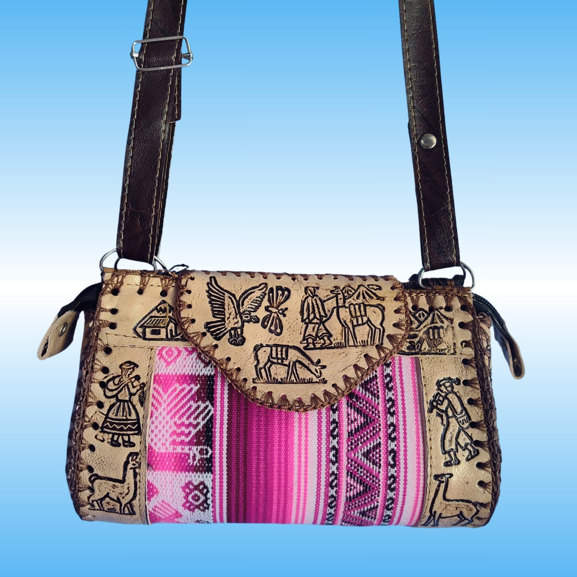 A handmade crossbody bag with a tan woven body featuring black embroidered motifs, a vibrant pink and purple striped textile panel, and dark brown leather straps.