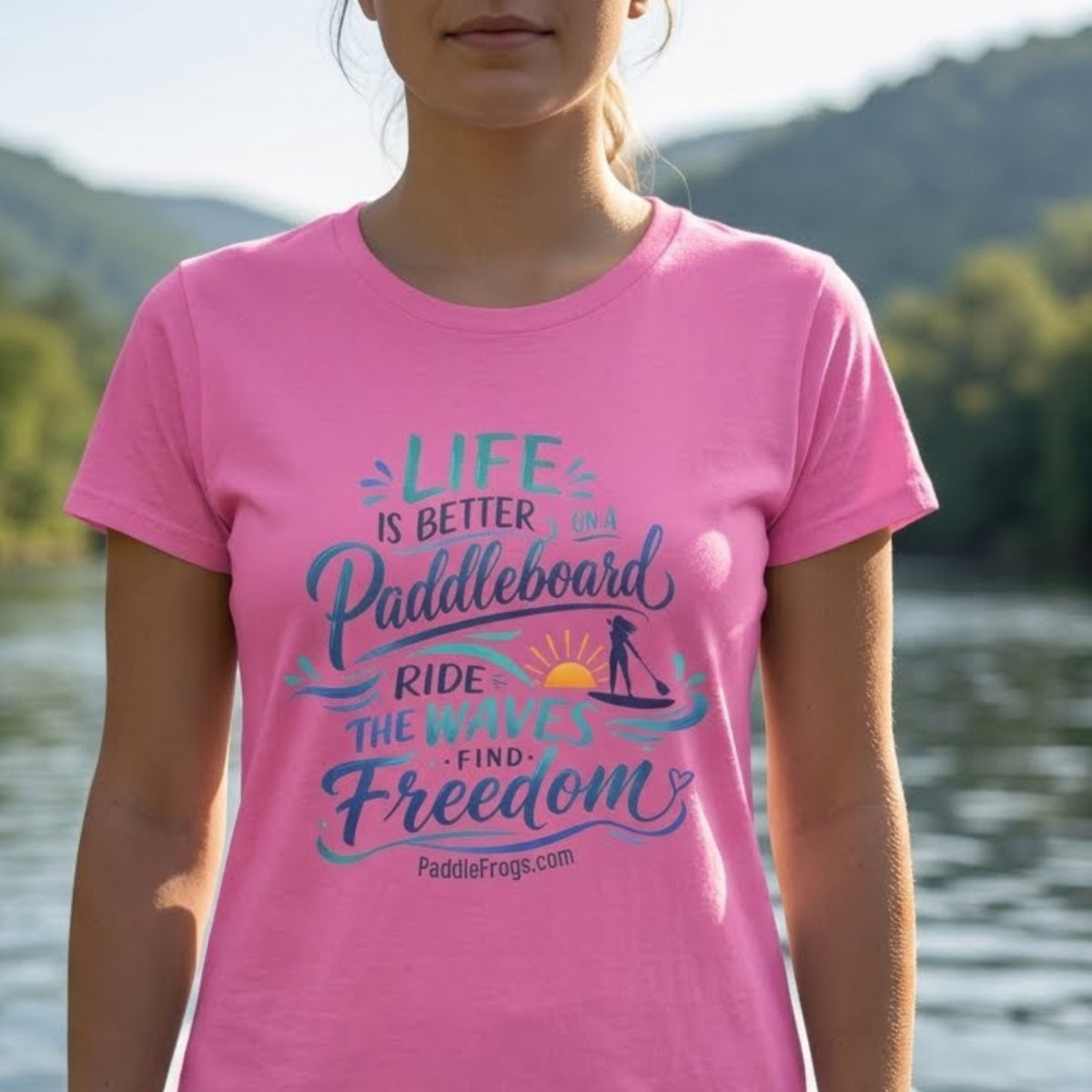a gen z lady paddleboarding in the Emory River in TN. Close up and in focus of the Life Is Better on a Paddleboard Women’s Tee by Paddle Frogs™ Outdoor Gear. Azalea pink color.