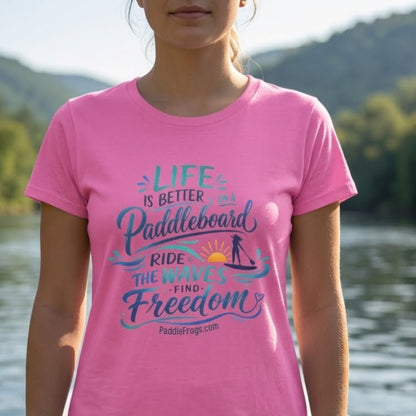 a gen z lady paddleboarding in the Emory River in TN. Close up and in focus of the Life Is Better on a Paddleboard Women’s Tee by Paddle Frogs™ Outdoor Gear. Azalea pink color.