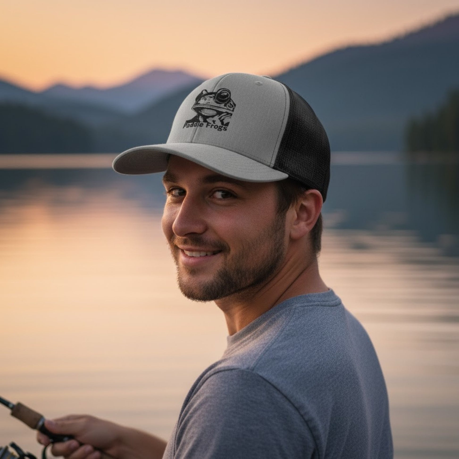 Male model wearing Paddle Frogs™ Snapback Cap heather grey and black vented mesh at the lake