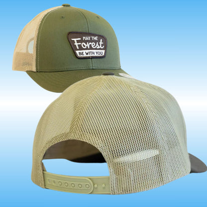 Two views of a trucker hat: one showing the front with an olive green front panel, beige mesh back, and a brown patch reading 'May the Forest Be with You'; the other showing the back with a beige mesh crown and olive green adjustable strap.