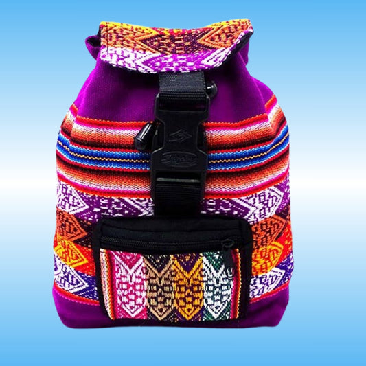 A small drawstring backpack with a purple base and vibrant, multicolored woven geometric patterns on the front and flap. It features a black plastic buckle strap closure and a front zippered pocket, set against a light blue gradient background.