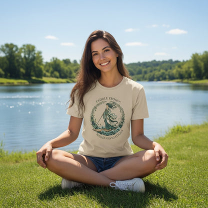 NAIAD NAVIGATIONS | Paddle Frogs: T-shirt | Sand tan color with our brunette model sitting crisscross applesauce at the river