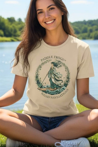 Young lady sitting crisscross applesauce wearing the Naiad Navigations: The "Paddle Frogs" Aquatic Odyssey T-Shirt