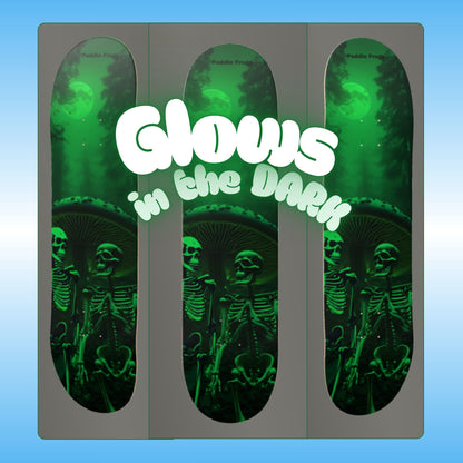 Nighttime Nonsense glow in the dark skateboard deck by Paddle Frogs | Three angles of a skateboard deck with skeletons and 'Glow in the Dark' text on a blue background