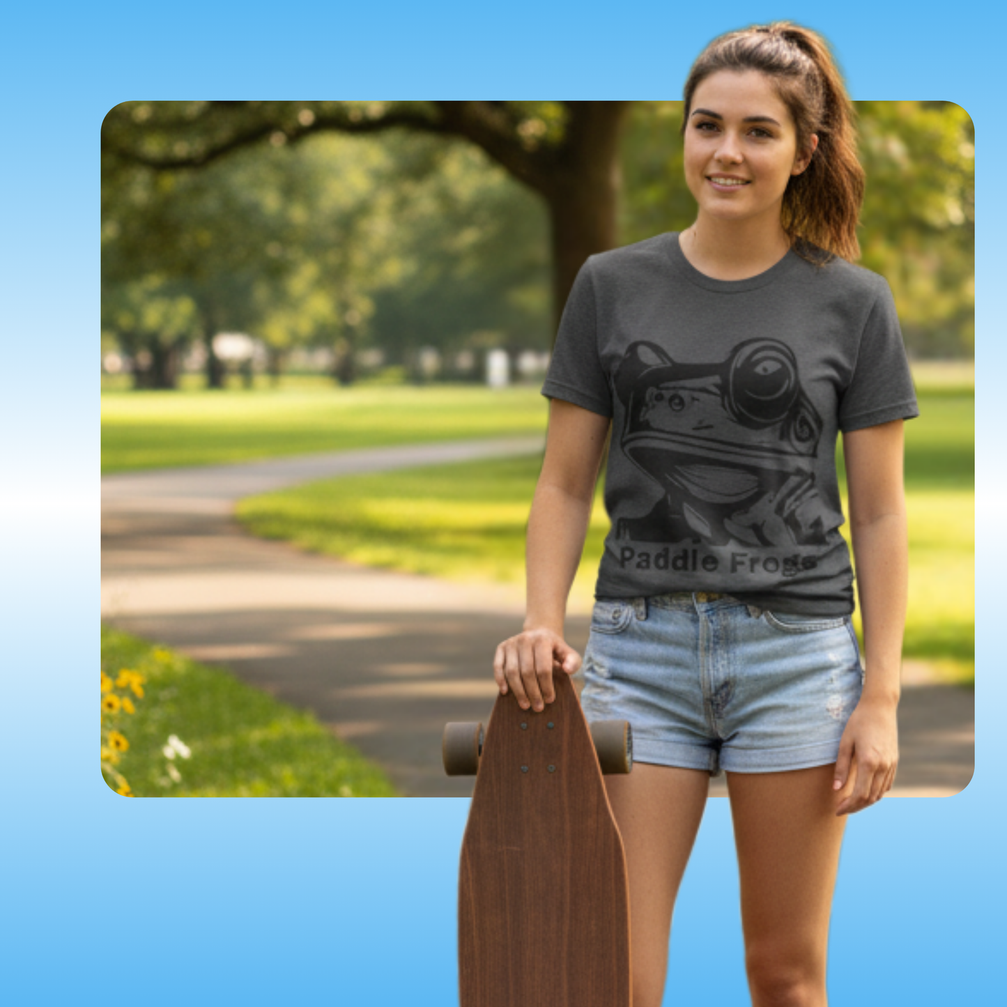 Olive Chaos Meets Sea Queen | Paddle Frogs™ Skate Tee | Woman wearing a t-shirt with a graphic design, holding a skateboard in a park.