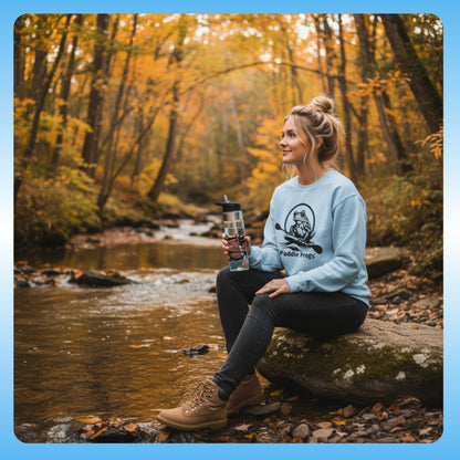  and crystal clear water bottle | Paddle Frogs™ Sweatshirt light blue | Woman sitting by a stream in a forest during autumn, holding a water bottle.