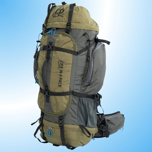 75+ Liter Backpacking Pack | Room to Roam Paddle Frogs. A large hiking backpack in olive green and gray with black straps and buckles, shown on a light blue gradient background. The brand name 'LIFE IN A PACK' is printed vertically on the front pocket.