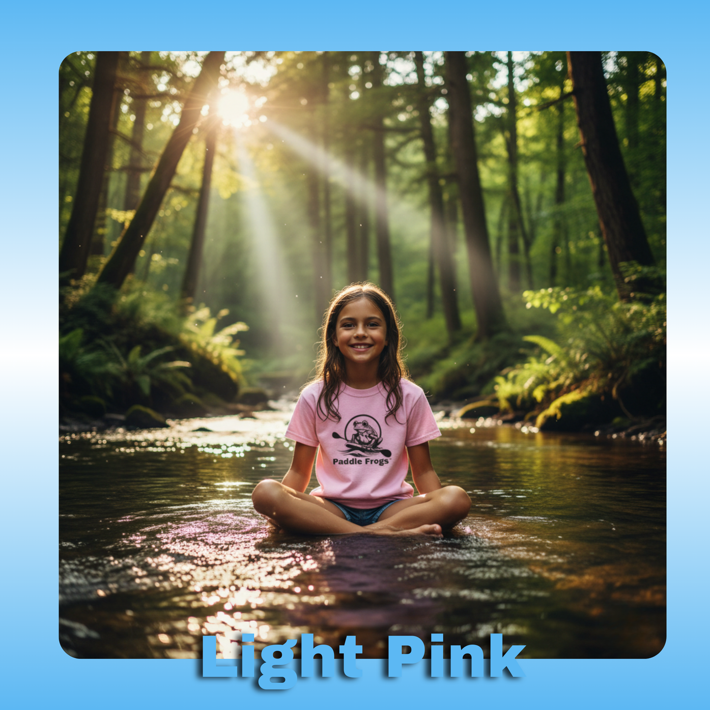 Paddle Frogs Kids T-Shirts | Light Pink with a 10 year old girl in the creek sitting crisscross applesauce | Girl sitting in a forest stream with sunlight filtering through the trees, wearing a light pink shirt.