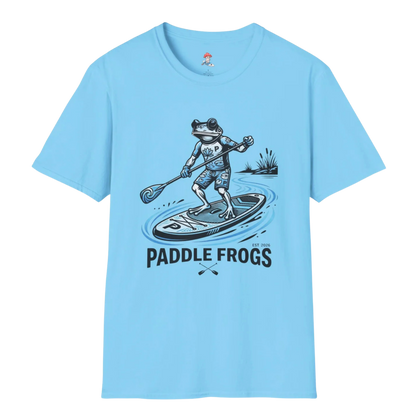 A light sky blue short-sleeve crewneck 100% cotton t-shirt featuring a graphic of a frog paddleboarding with the text 'PADDLE FROGS' printed below it.