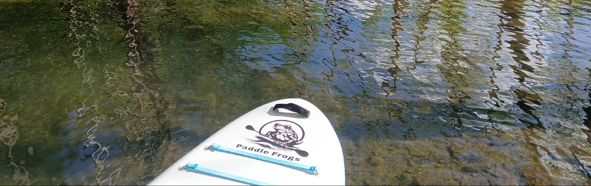 Paddleboard on a calm river with trees and rocks in the background
