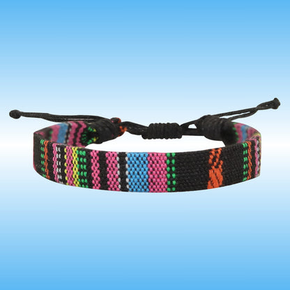 A woven adjustable boho cord bracelet with a black base and vertical stripes of pink, blue, green, orange, and white, shown against a blue gradient background.