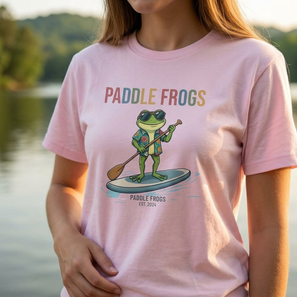 A woman wearing the Paddling Frog Tee by Paddle Frogs Outdoor Gear brand a frog paddling in glasses and a vacation Hawaiian shirt light pink paddleboard t-shirt
