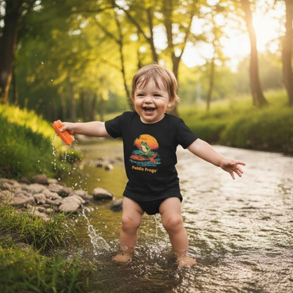 Playing in the creek wearing the black Sunset Frog Paddle Board Explorer Toddler Tee "Skate & Paddle Frogs™ 