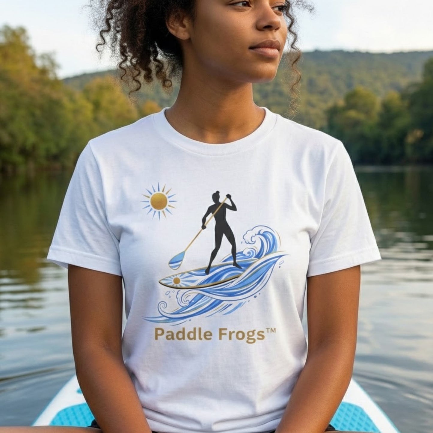 Relaxing on the Divine Escape paddle board wearing the "Sun Stoke" High-Quality Stand-Up Paddleboard T-Shirt – Premium Ring-Spun Cotton SUP Tee Person wearing a white t-shirt with 'Paddle Frogs' design by a lake