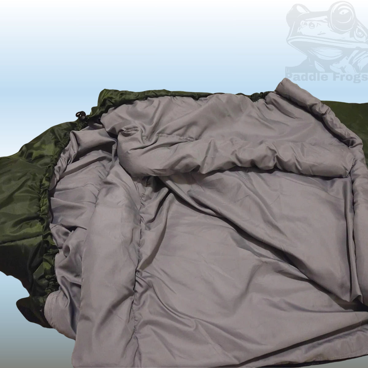A close-up of a camping sleeping bag showing the gray quilted puffer fabric and the olive green water-resistant outer shell, with a faint 'Paddle Frog' logo watermark in the top right corner.